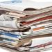 A stack of local newspapers with focus on front. Shallow DOF